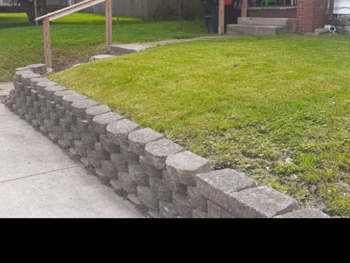 Crisp lawn edge along sidewalk and retaining wall