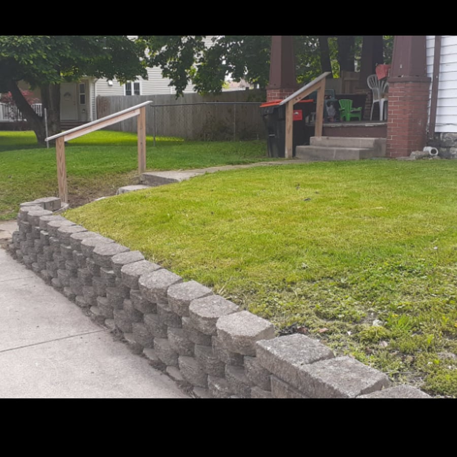 After: mowed lawn, rebuilt retaining wall, and new handrails